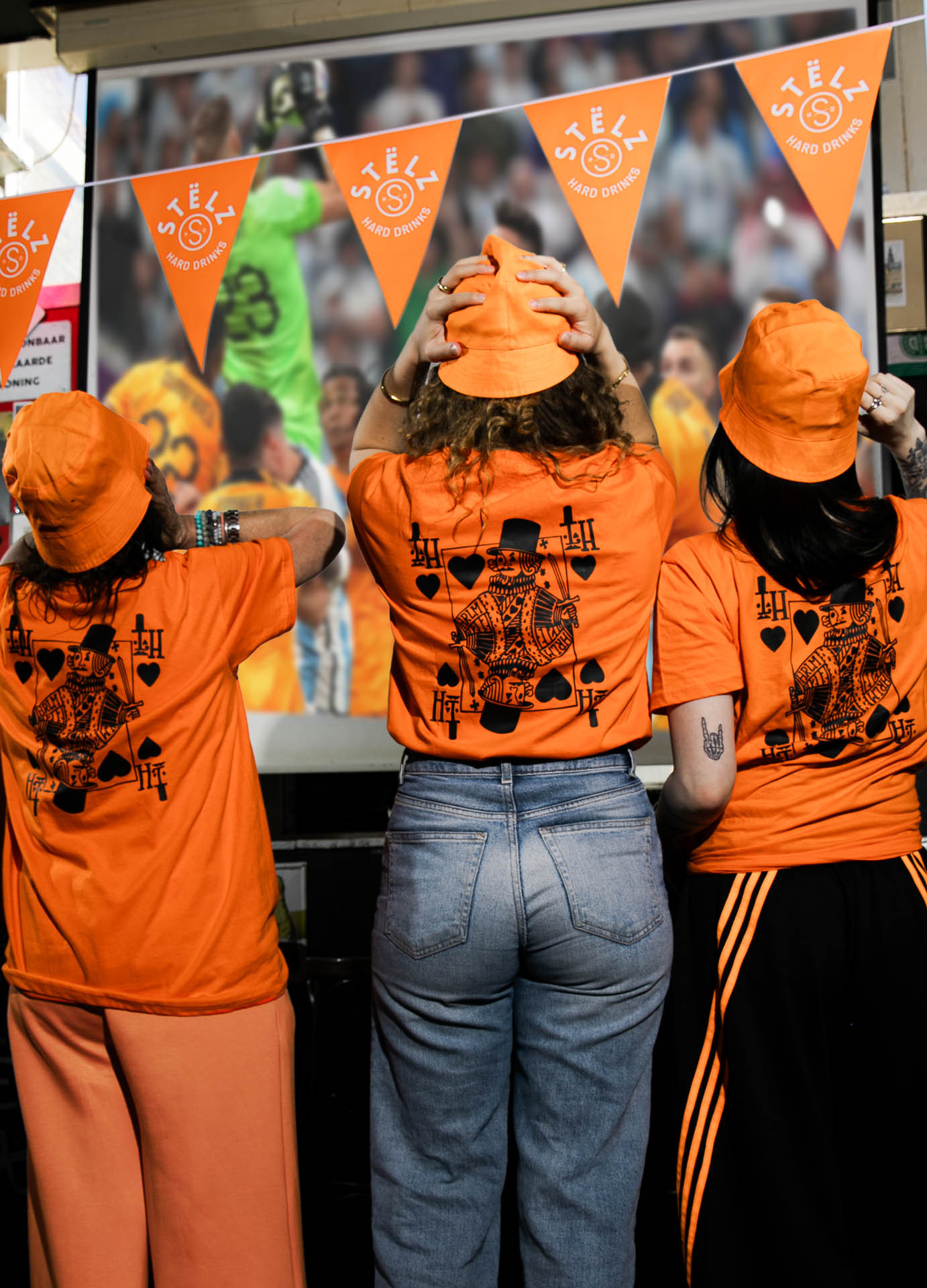 Drie gasten in WK-kit voor het scherm